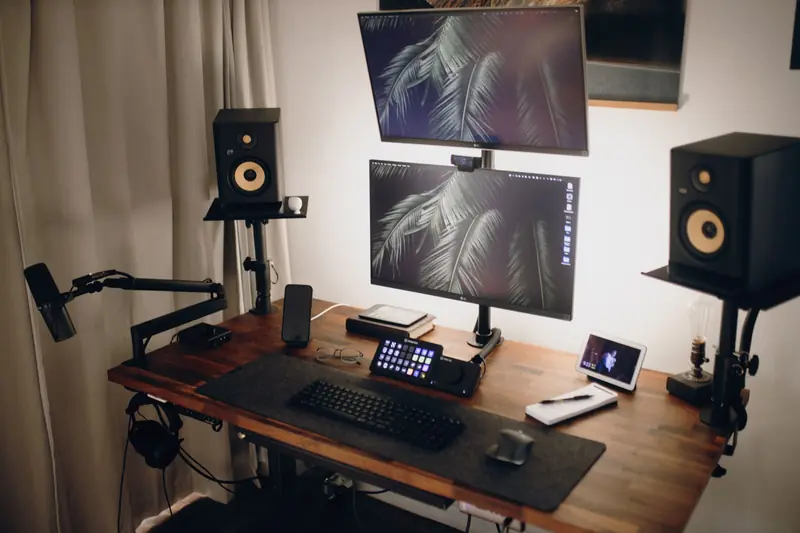 Contemporary streaming setup featuring dual monitors, speakers, and accessories on a wooden desk