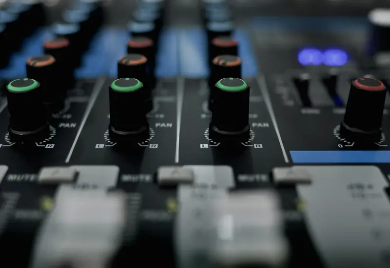 Detailed close-up of audio mixer knobs in a recording studio setting