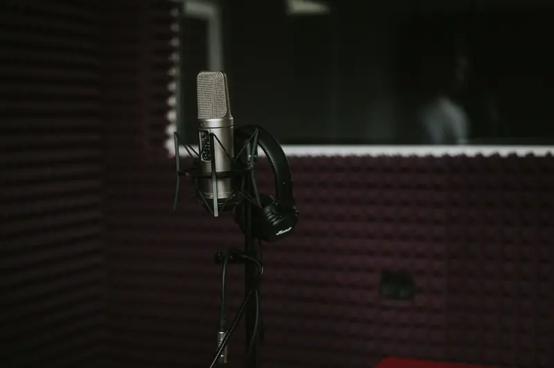 Close-up of a microphone with headphones in a soundproof recording studio