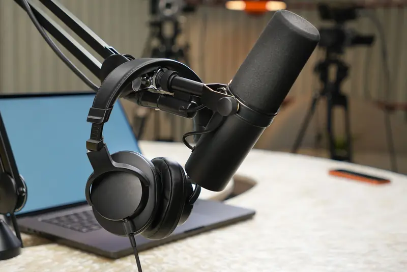 Close-up of a podcast studio setup featuring a microphone and headphones