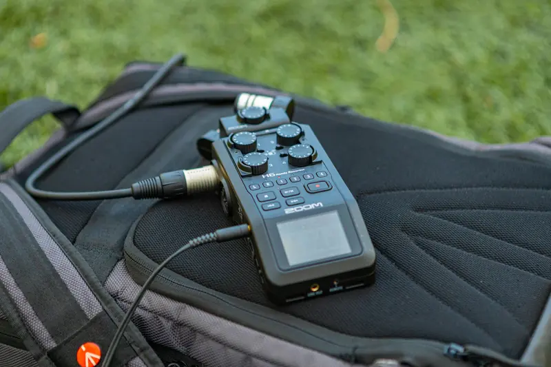 Close-up of a portable audio recorder on a backpack, ideal for outdoor recording