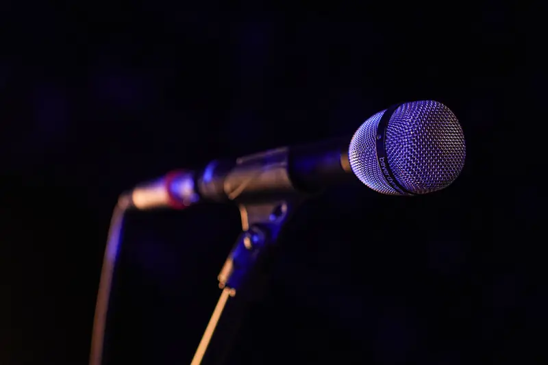 Close-up of a microphone set up on stage, highlighting concert ambiance